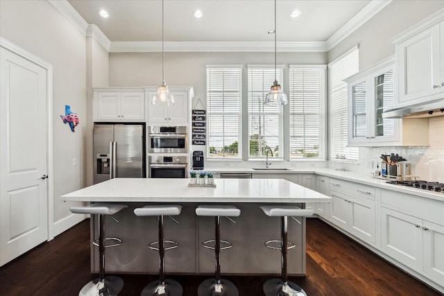 kitchen featuring a kitchen island, appliances with stainless steel finishes, a breakfast bar, and a sink