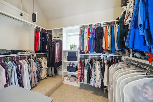 walk in closet with carpet and lofted ceiling