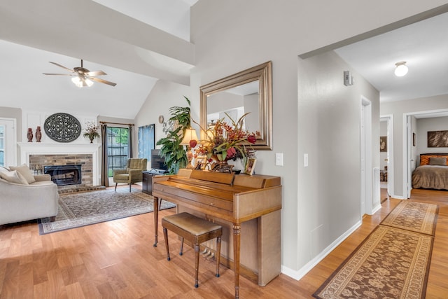 corridor featuring baseboards, light wood-style flooring, and high vaulted ceiling