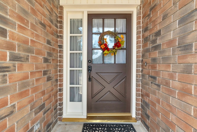 view of exterior entry with brick siding
