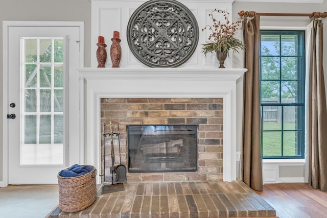 interior details featuring a brick fireplace and wood finished floors