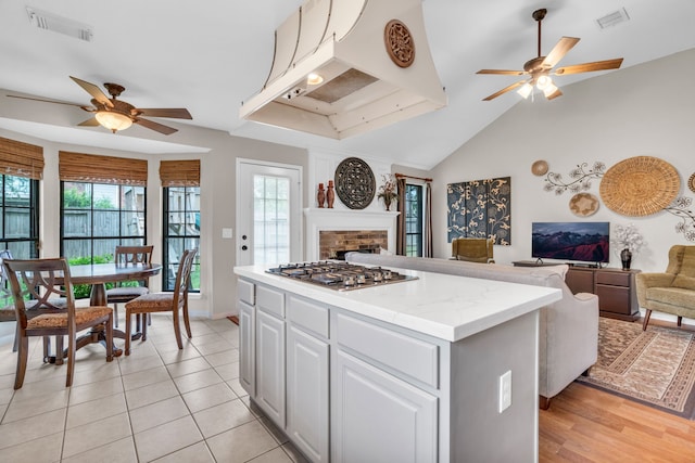 kitchen with ceiling fan, stainless steel gas cooktop, visible vents, and open floor plan
