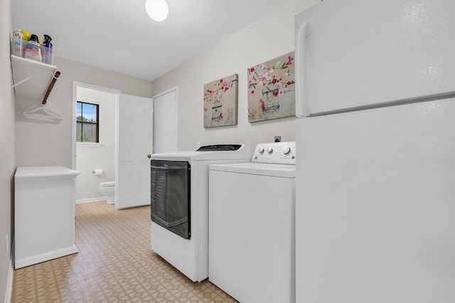 clothes washing area with light floors, baseboards, laundry area, and washer and clothes dryer