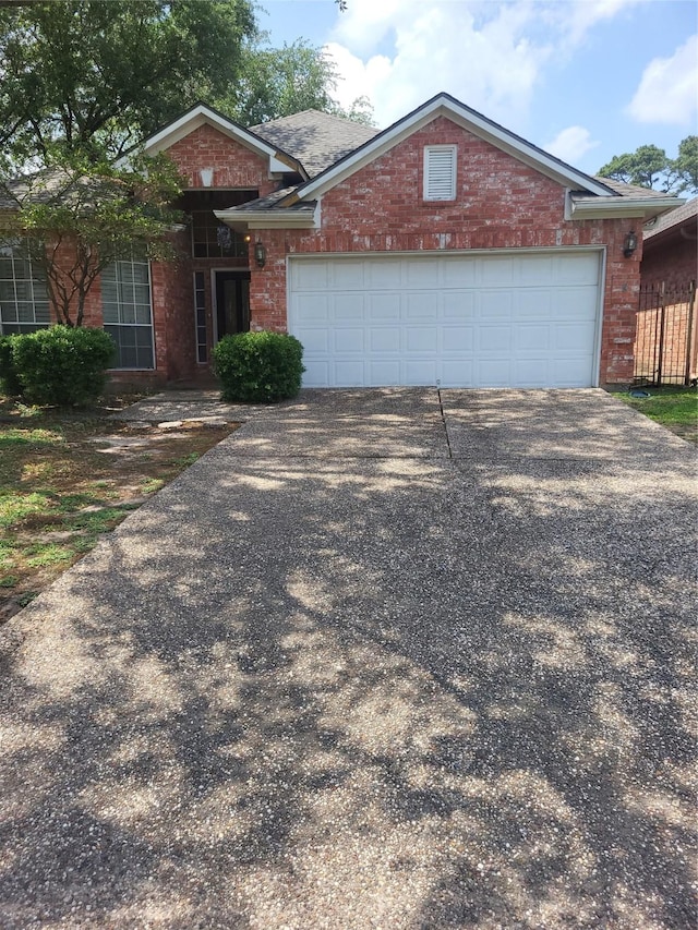 view of front of home with a garage, driveway, and brick siding