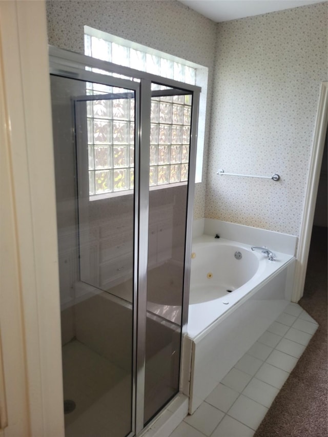 full bathroom featuring wallpapered walls, a tub with jets, a wealth of natural light, and tile patterned flooring
