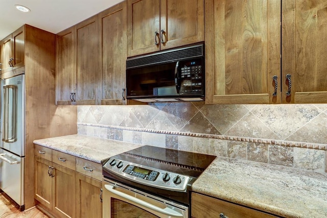 kitchen with brown cabinetry, light stone counters, tasteful backsplash, and stainless steel appliances