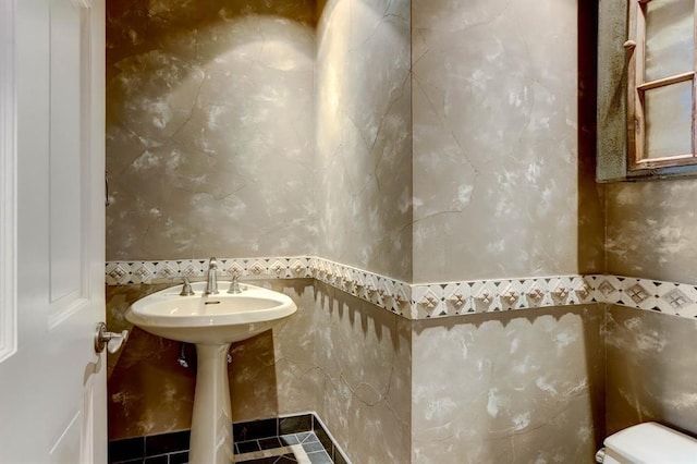 bathroom featuring tile walls and toilet