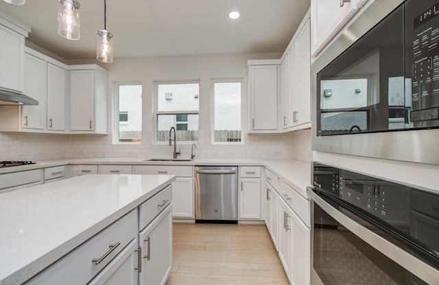 8815 Drysdale River Rd, Cypress, TX 77433 - kitchen featuring a sink, light countertops, backsplash, and stainless steel appliances