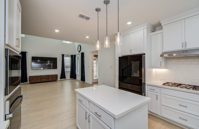 8815 Drysdale River Rd, Cypress, TX 77433 - kitchen with under cabinet range hood, recessed lighting, stainless steel gas cooktop, and decorative backsplash