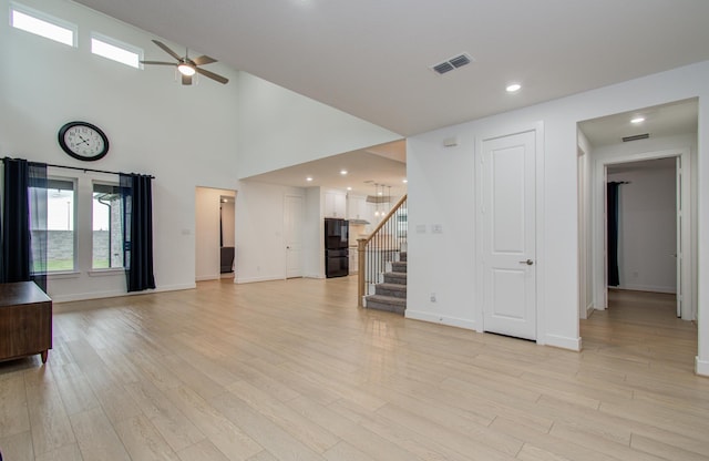 8815 Drysdale River Rd, Cypress, TX 77433 - unfurnished living room with light wood finished floors, stairs, a ceiling fan, baseboards, and visible vents