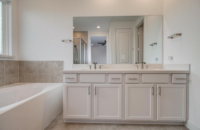 8815 Drysdale River Rd, Cypress, TX 77433 - full bathroom featuring a sink, double vanity, a shower stall, and a garden tub