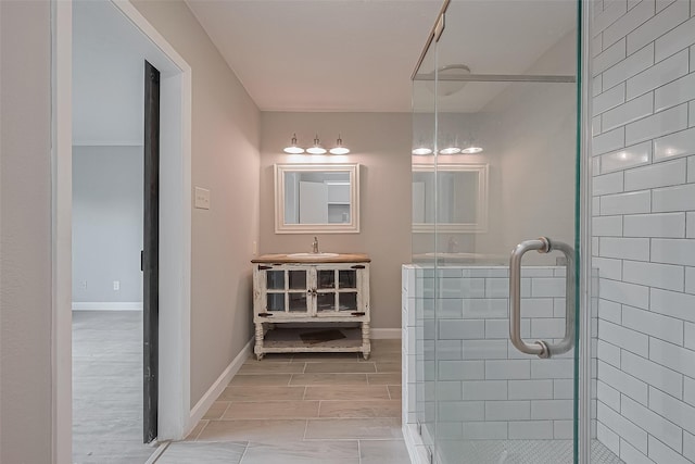 full bathroom with vanity, baseboards, a shower stall, and wood finished floors
