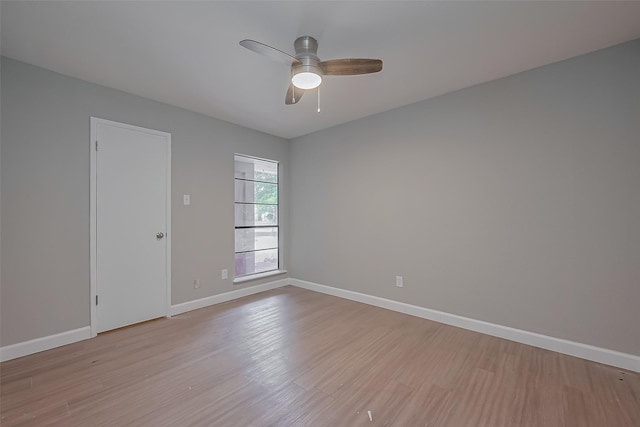 unfurnished room with baseboards, a ceiling fan, and light wood-style flooring