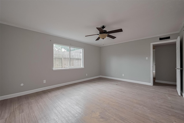 unfurnished room with crown molding, visible vents, wood finished floors, baseboards, and ceiling fan