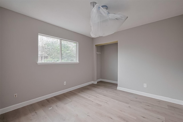 empty room featuring baseboards and light wood-style flooring