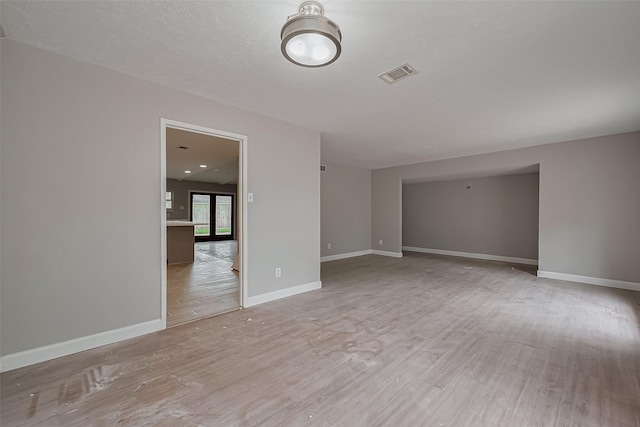 spare room with visible vents, baseboards, and wood finished floors