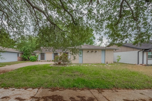 ranch-style home featuring a front yard and brick siding