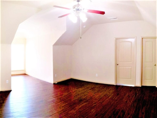 additional living space with ceiling fan, vaulted ceiling, and dark wood-style floors