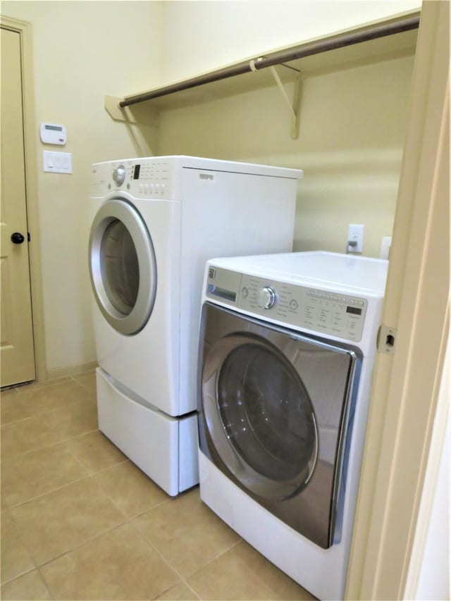 washroom featuring light tile patterned floors, separate washer and dryer, and laundry area