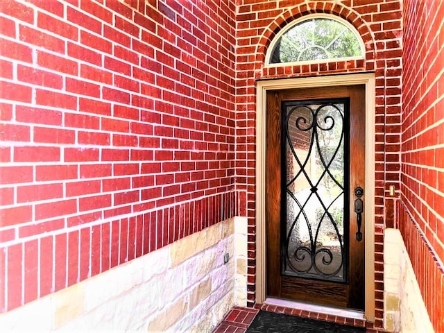 entrance to property featuring brick siding