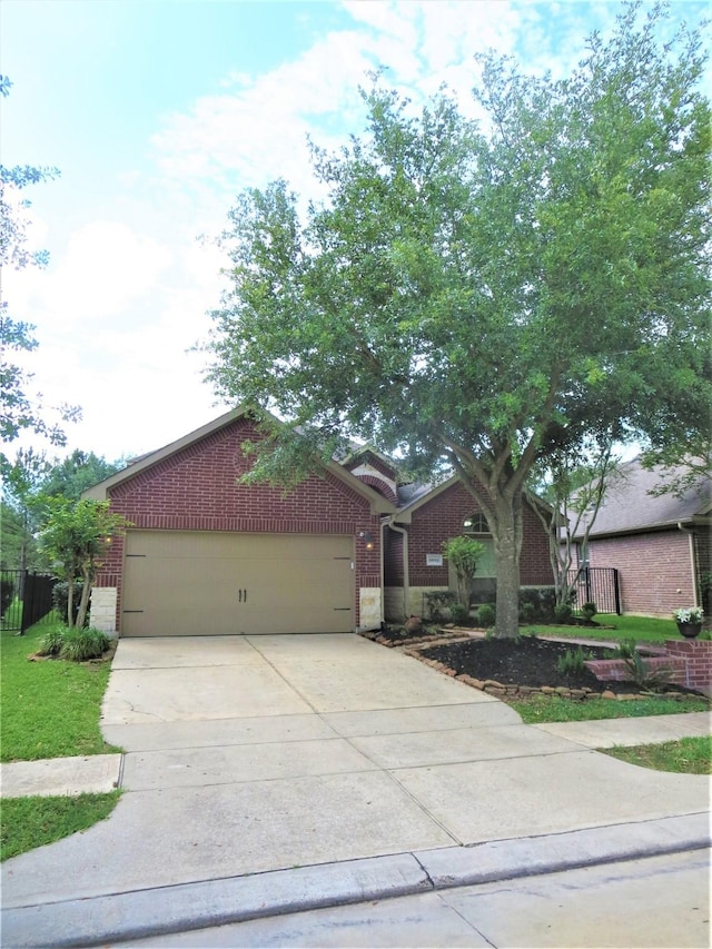 ranch-style home with a garage, fence, driveway, and brick siding