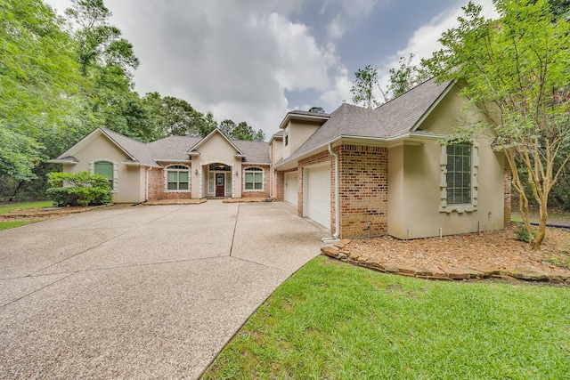 ranch-style home featuring driveway, roof with shingles, a garage, brick siding, and stucco siding