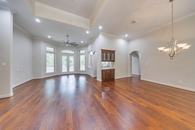 unfurnished living room with dark wood-style flooring, recessed lighting, french doors, arched walkways, and ceiling fan with notable chandelier