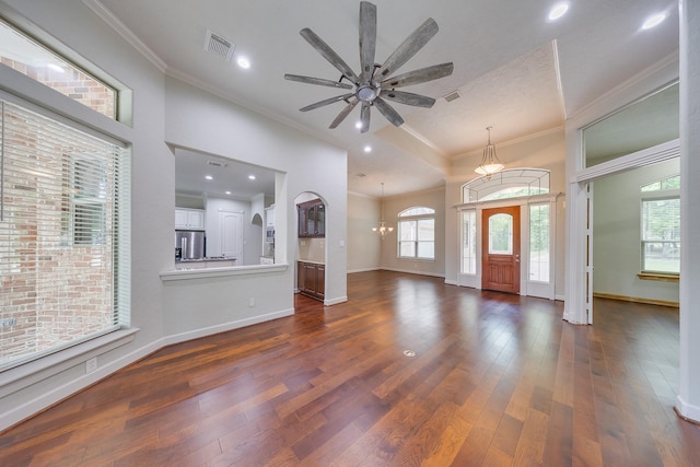 entrance foyer featuring dark wood-style flooring, visible vents, baseboards, ceiling fan with notable chandelier, and ornamental molding
