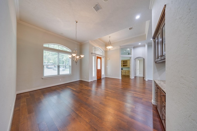 interior space with crown molding, dark wood finished floors, a chandelier, and visible vents