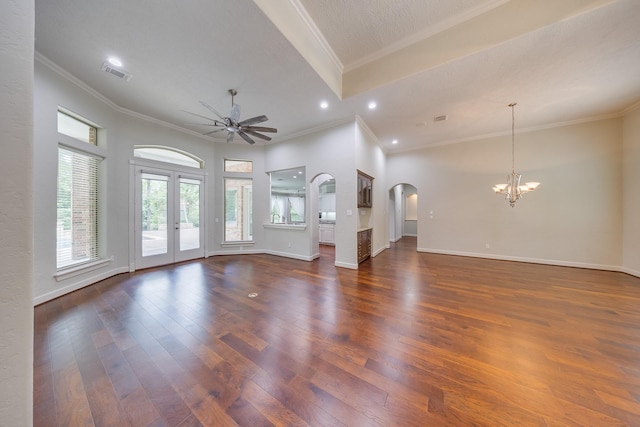unfurnished living room featuring visible vents, arched walkways, ceiling fan with notable chandelier, dark wood-style floors, and ornamental molding