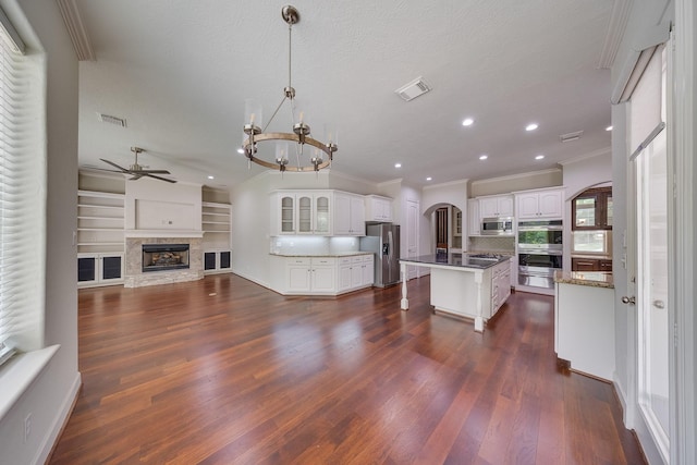 kitchen featuring visible vents, crown molding, ceiling fan with notable chandelier, and stainless steel appliances