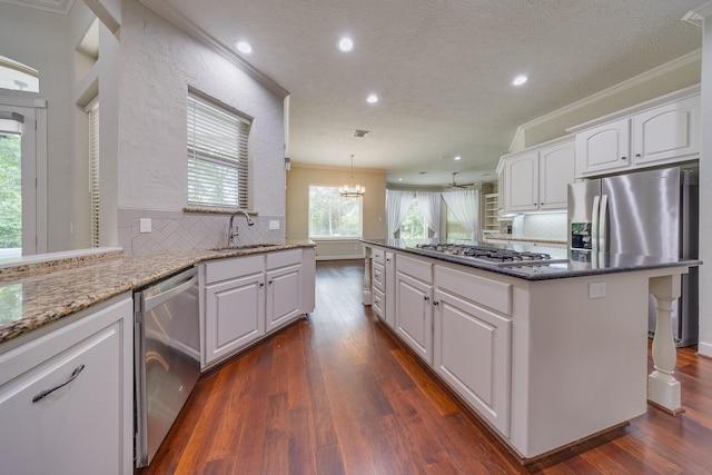 kitchen featuring a sink, white cabinetry, backsplash, and stainless steel appliances