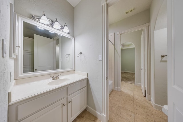 full bath with vanity, a bathtub, and visible vents