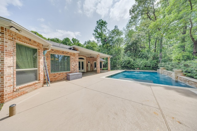 outdoor pool with a patio and french doors