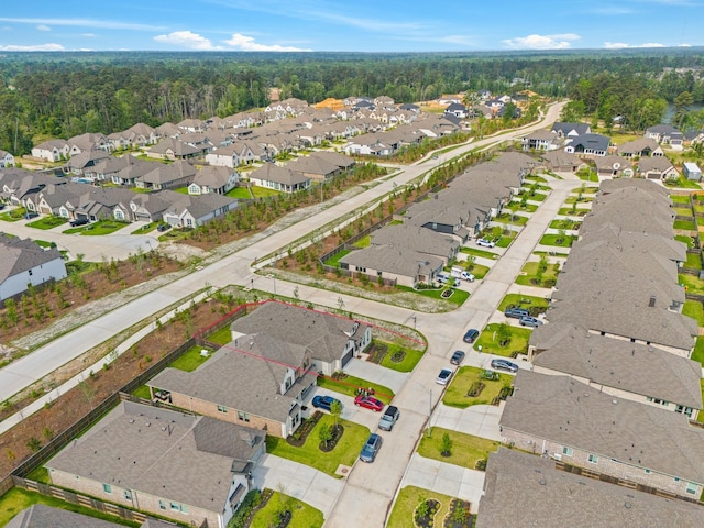 drone / aerial view with a wooded view and a residential view