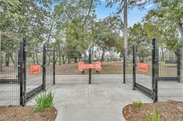 view of basketball court featuring fence and a gate