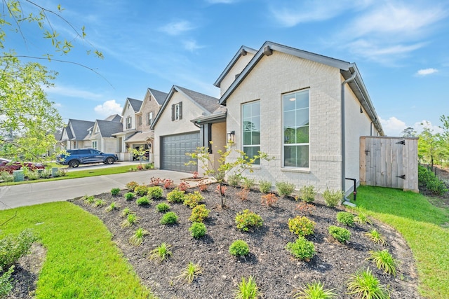 view of front of property featuring a residential view, fence, concrete driveway, an attached garage, and stucco siding