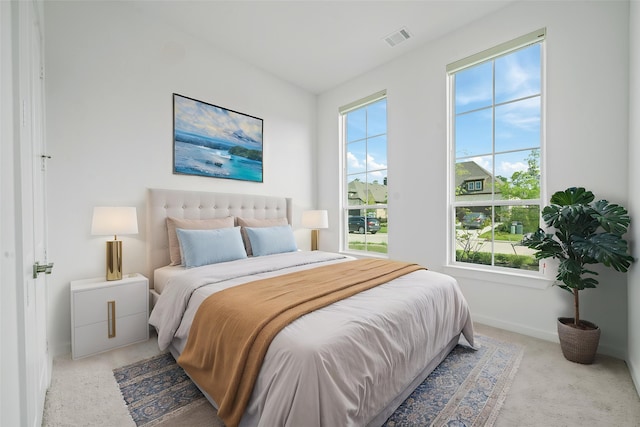 bedroom with baseboards, light carpet, and visible vents