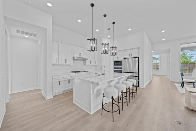kitchen featuring visible vents, a sink, light wood-style floors, and appliances with stainless steel finishes