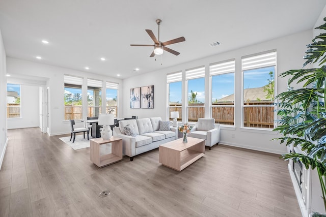 living room with recessed lighting, ceiling fan, baseboards, and light wood finished floors