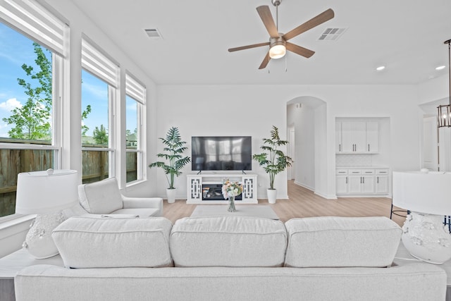 living room featuring ceiling fan, visible vents, and light wood finished floors
