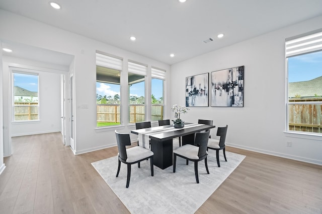 dining room featuring plenty of natural light, light wood-style flooring, and visible vents