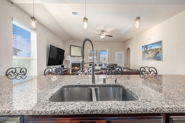 23414 Bracino Lake Dr, Katy, TX 77493 - kitchen featuring visible vents, a ceiling fan, open floor plan, a lit fireplace, and a sink