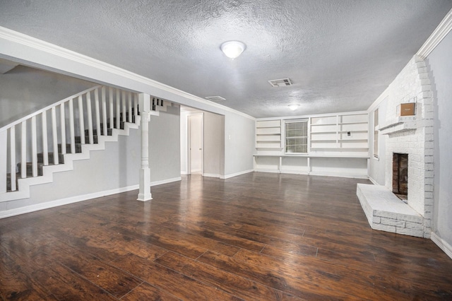 unfurnished living room with a fireplace, a textured ceiling, hardwood / wood-style floors, visible vents, and stairway