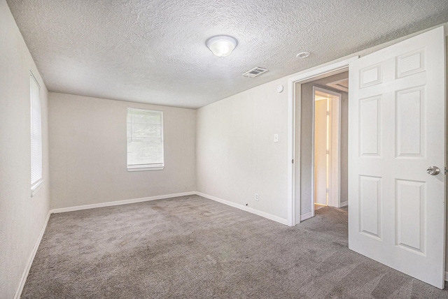 unfurnished room with carpet flooring, baseboards, and visible vents