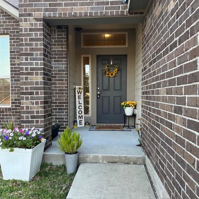 view of exterior entry with brick siding