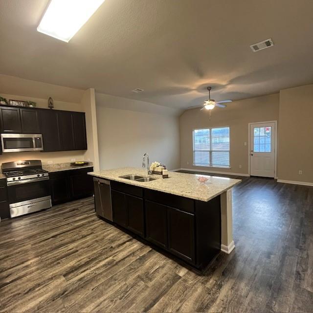 kitchen featuring a sink, appliances with stainless steel finishes, dark wood-style flooring, and visible vents