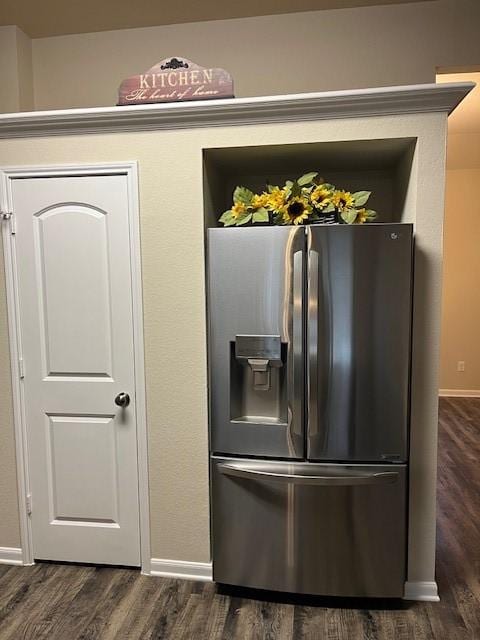 details with baseboards, stainless steel fridge, and dark wood-type flooring