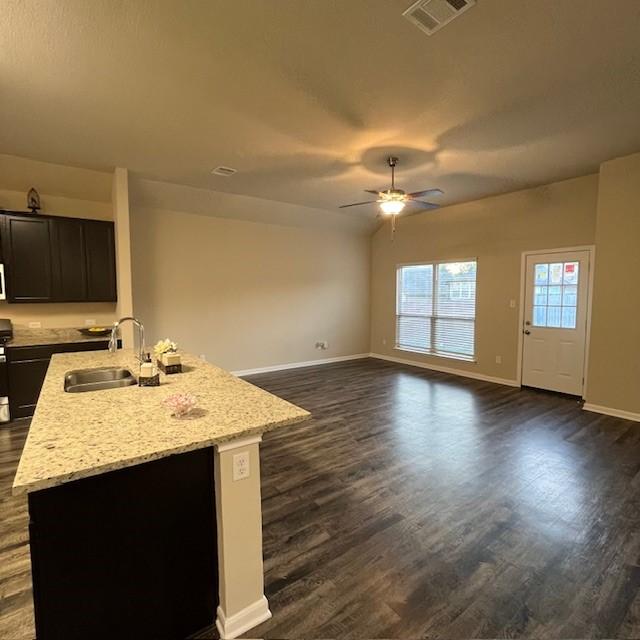 135 Bates Ct, Huntsville, TX 77320 - kitchen featuring a sink, dark wood-style flooring, baseboards, ceiling fan, and light stone counters