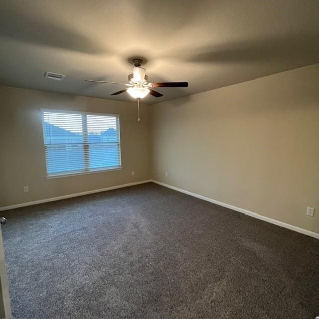 unfurnished room featuring baseboards, a ceiling fan, and dark colored carpet